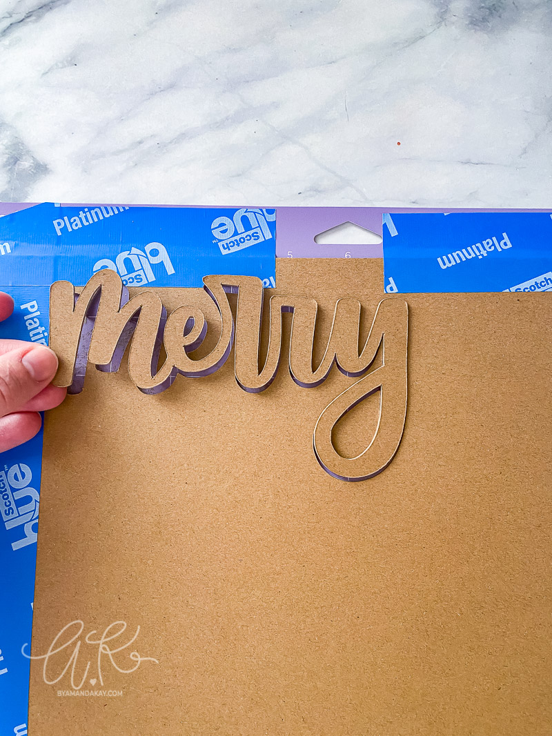 the word merry popping out of the chipboard material